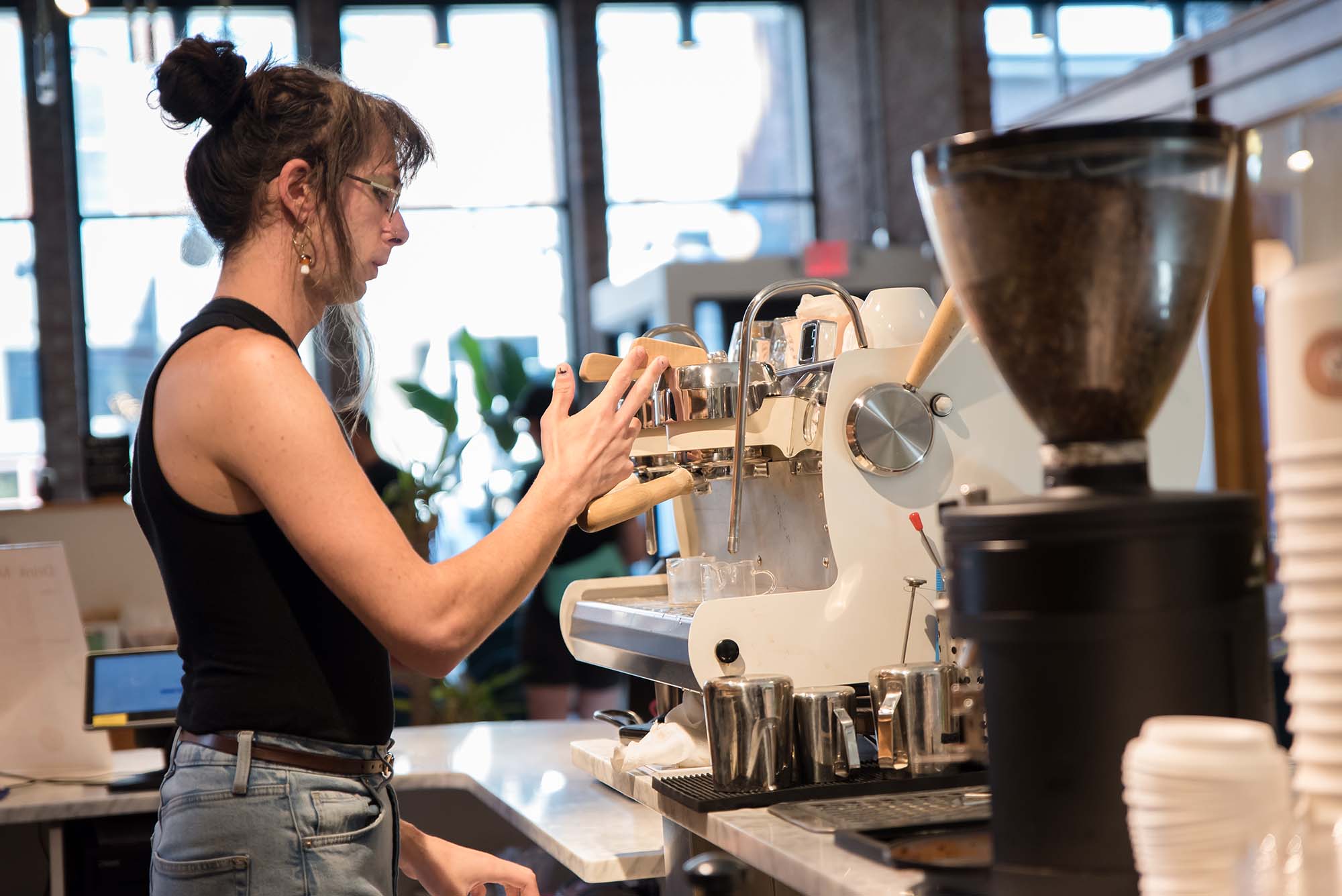 a photo of June making a speciality coffee drink at Oliver's Donuts